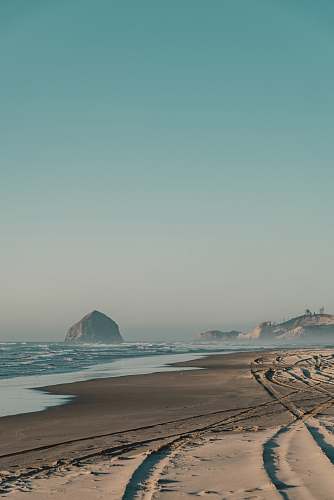 pacific city rock formation on water near seashore at daytime beach